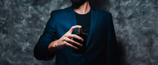 man spraying himself with cologne