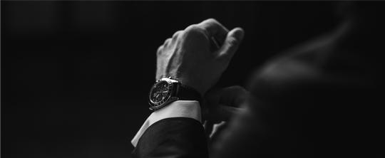 man in suit adjusting watch